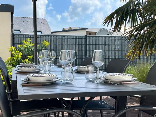 - une table avec des verres à vin et des assiettes dans l'établissement L'Océane Maison avec jardin, à Vannes