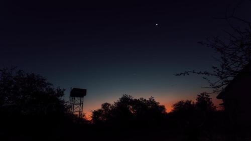 a sky with a water tower in the distance at Umkhaya lodge in Mkuze