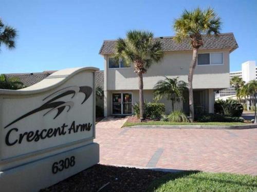 a sign in front of a building with palm trees at Crescent Arms Condominiums in Siesta Key