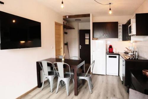 une cuisine avec une table et des chaises dans une pièce dans l'établissement Residence La Combe D Or - Appartement en résidence de standing MAE-6334, aux Orres