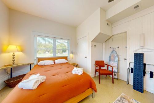 a bedroom with a large orange bed and a chair at Rehoboth Beach --- 35526 Dry Brook Dr in Rehoboth Beach
