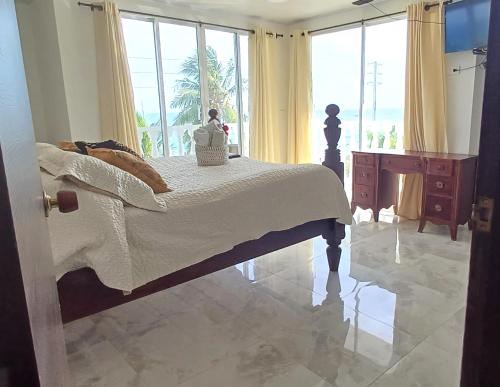 a bedroom with a bed and a large window at Sunset Paradise in San Andrés