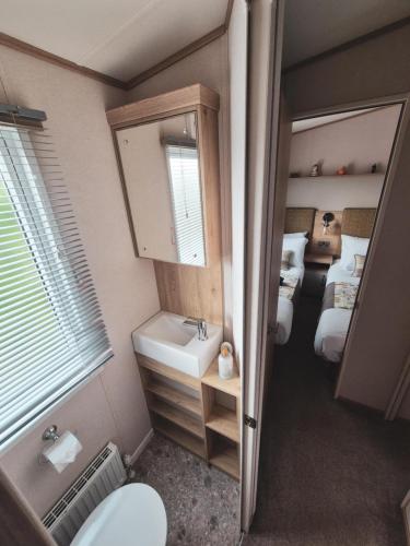 a bathroom with two beds and a sink and a mirror at The Ticehurst Haven in Westgate on Sea