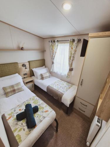 a small bedroom with two beds and a mirror at The Ticehurst Haven in Westgate on Sea