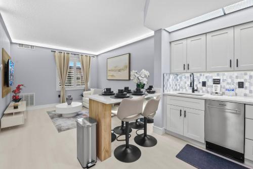 a kitchen with white cabinets and a table and chairs at Spacious 1BR near Universal I-Drive in Orlando