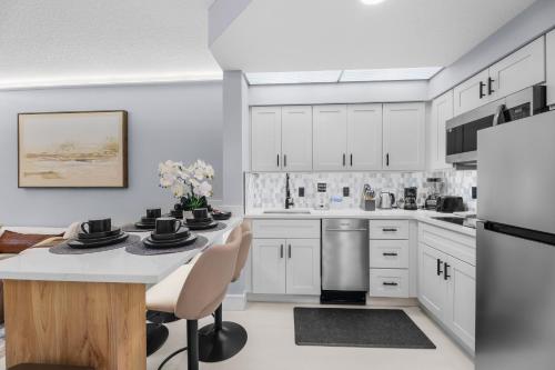 a kitchen with white cabinets and a table with chairs at Spacious 1BR near Universal I-Drive in Orlando