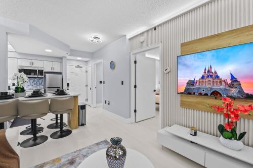 a kitchen and living room with a large tv on a wall at Spacious 1BR near Universal I-Drive in Orlando