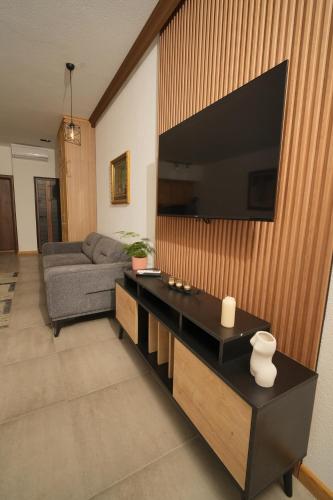a living room with a couch and a television on a wall at Suites Castello in Bar