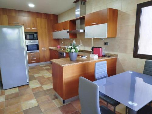 a kitchen with a counter and a table with chairs at Casa de Luis a 10 min Puy du Fou in Burguillos de Toledo