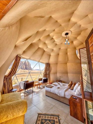 a bedroom with a bed in a room with a large window at environment wadi rum in Wadi Rum