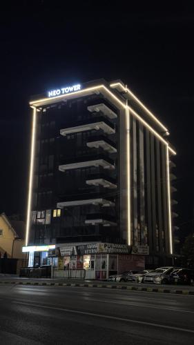 a hotel with a sign on top of it at night at Luxe Apartment - NEO TOWER in Suceava