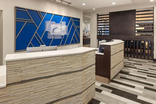a lobby with a counter with a blue wall at Holiday Inn Express Moline - Quad Cities Area by IHG in Moline