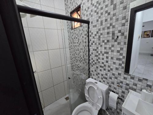 a bathroom with a toilet and a shower and a sink at Casa completa dois quartos, com ar condicionado, churrasqueira, garagem in Aparecida de Goiania