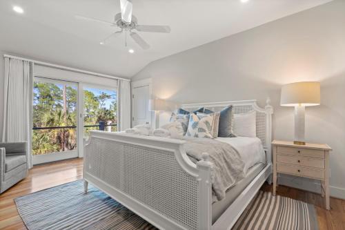 a white bedroom with a bed and a window at 113 Blue Heron Pond Road by Akers Ellis Rentals in Kiawah Island