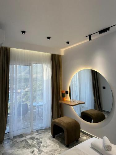 a bedroom with a mirror and a bed and a table at Hotel Mesun Himare in Himare