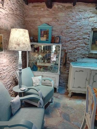 a living room with a chair and a table with a lamp at Traditional stone house in Pelion in Rodhiás