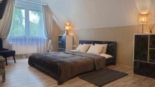 a bedroom with a bed and a large window at Rugpieniai in Jadagoniai