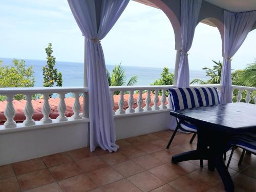 a balcony with a table and a view of the ocean at Caribbean Sea View Holiday Apartments in Méro