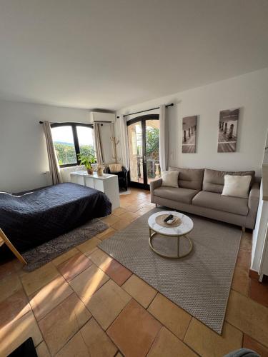 un salon avec un lit et un canapé dans l'établissement Maison Lou, à Falicon
