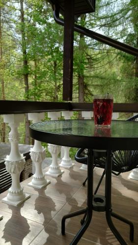 a glass sitting on top of a table on a porch at Rugpieniai in Jadagoniai