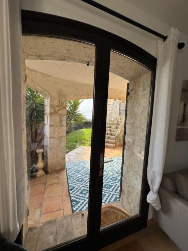 d'une porte coulissante en verre avec vue sur la terrasse. dans l'établissement Maison Lou, à Falicon