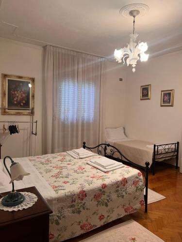 a bedroom with two beds and a chandelier at Gold House in Maranello