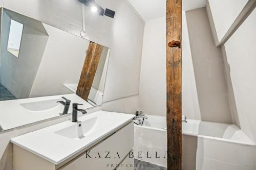 une salle de bain avec un lavabo et un miroir dans l'établissement KAZA BELLA - Deauville - Bel appartement dans un élégant château, à Deauville