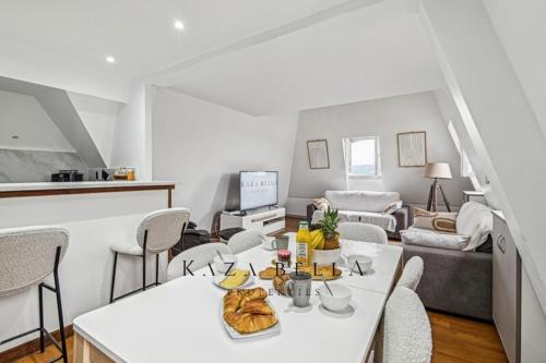 un salon avec une table et des chaises blanches dans l'établissement KAZA BELLA - Deauville - Bel appartement dans un élégant château, à Deauville