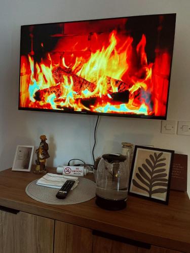 a tv sitting on top of a wooden table with a fire at Whispering Pines in Šišava