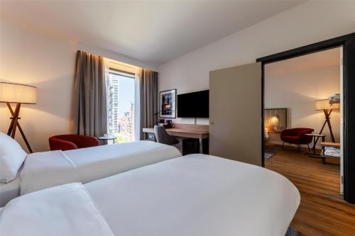a hotel room with two beds and a mirror at Radisson Hotel Manchester City Centre, A Verified Net Zero Hotel in Manchester