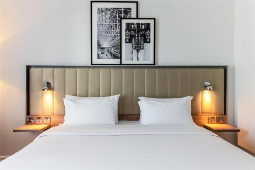 a bedroom with a large white bed with two lamps at Radisson Hotel Manchester City Centre, A Verified Net Zero Hotel in Manchester