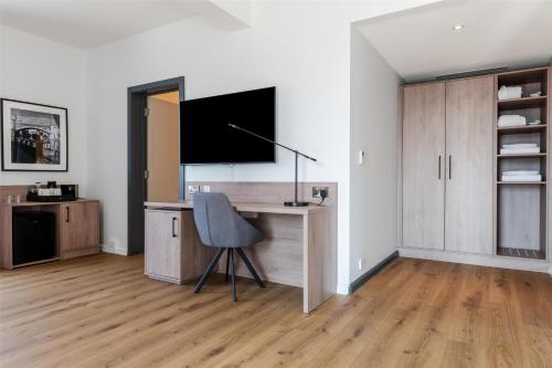 a room with a desk with a tv and a chair at Radisson Hotel Manchester City Centre, A Verified Net Zero Hotel in Manchester