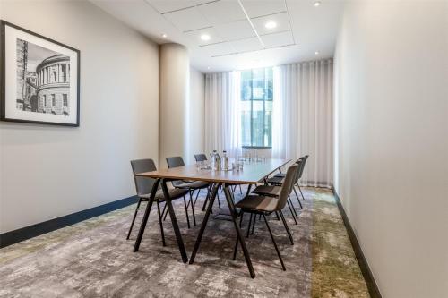 a conference room with a wooden table and chairs at Radisson Hotel Manchester City Centre, A Verified Net Zero Hotel in Manchester