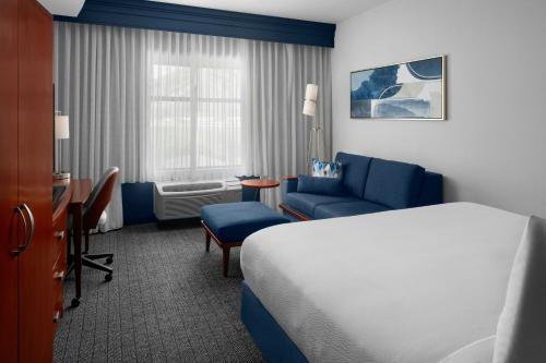a hotel room with a bed and a chair at Courtyard by Marriott Santa Clarita Valencia in Valencia
