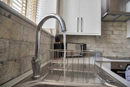 a kitchen sink with a water faucet in a kitchen at Iconic Apartment - Littleborough in Littleborough