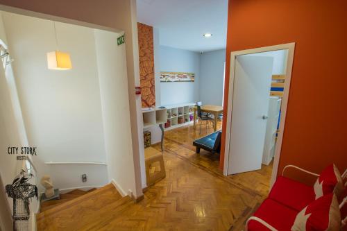 a living room with a red couch and an open door at City Stork Hostel in Portimão