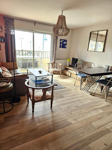 un salon avec une table et une salle à manger dans l'établissement Plazza front de Mer, à Villers-sur-Mer
