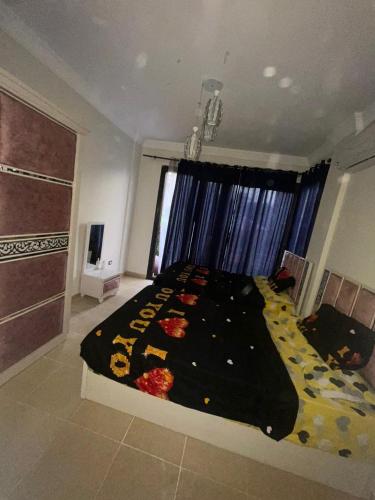 a bedroom with a large bed with a black comforter at فيلا دوبلكس في العين السخنة في قرية بلو باي أسيا عروس السخنة in Ain Sokhna