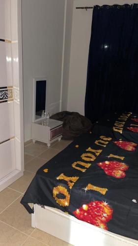 a bed with a black blanket with the words help at فيلا دوبلكس في العين السخنة في قرية بلو باي أسيا عروس السخنة in Ain Sokhna