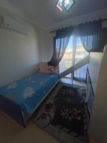 a small bedroom with a bed and a window at فيلا دوبلكس في العين السخنة في قرية بلو باي أسيا عروس السخنة in Ain Sokhna