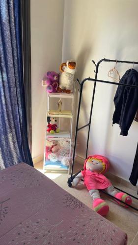 a bedroom with a bed and a shelf with stuffed animals at فيلا دوبلكس في العين السخنة في قرية بلو باي أسيا عروس السخنة in Ain Sokhna