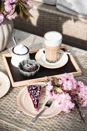 a table with a tray with a drink and a slice of cake at Landgasthaus & Hotel zur Krone in Dahn