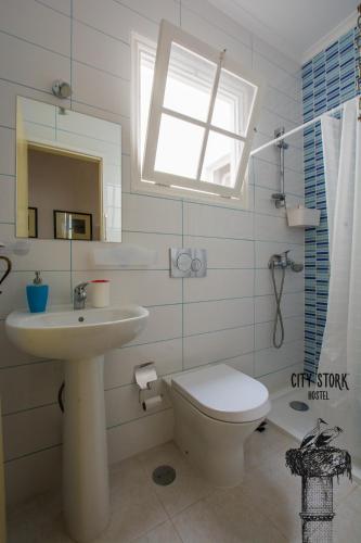 a bathroom with a sink and a toilet and a window at City Stork Hostel in Portimão