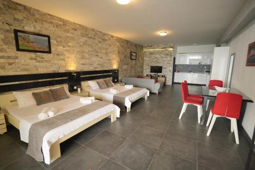 a hotel room with three beds and a table and chairs at Suites Castello in Bar