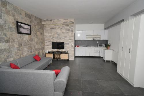 a living room with a couch and a kitchen at Suites Castello in Bar