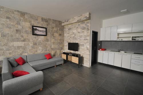 a living room with a couch and a kitchen at Suites Castello in Bar