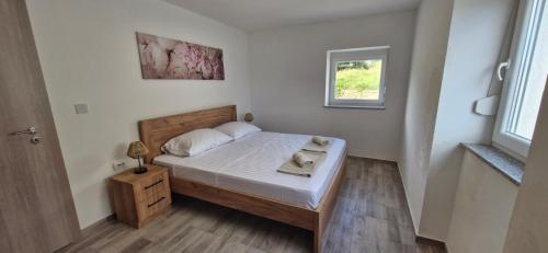a small bedroom with a bed and a window at Apartmani Lucija 2 in Zubovići
