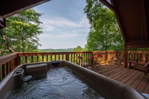 a hot tub on the deck of a cabin at Cute Studio Cabin! Views! Private. Hot Tub. Relax! in Sevierville