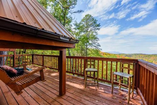 a deck with a bench and two stools at Cute Studio Cabin! Views! Private. Hot Tub. Relax! in Sevierville