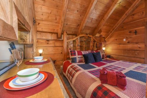 a log cabin bedroom with two beds and a table at Cute Studio Cabin! Views! Private. Hot Tub. Relax! in Sevierville